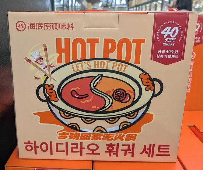 「海底捞火锅礼盒」的包装盒，上书：

海底捞调味料
LET’S HOT POT
今晚回家吃火锅
하이디라오 훠궈 세트

CELEBRATING 40 YEARS OF EXCELLENCE
H MART
창립 40주년 실속기획세트