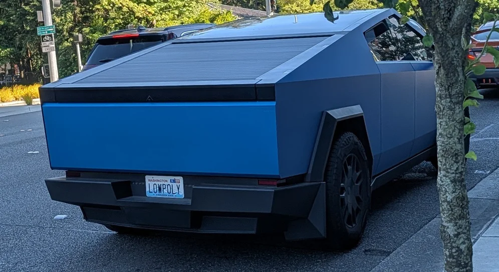 A Tesla Cyber truck coated in blue, with license plate `LOWPOLY`